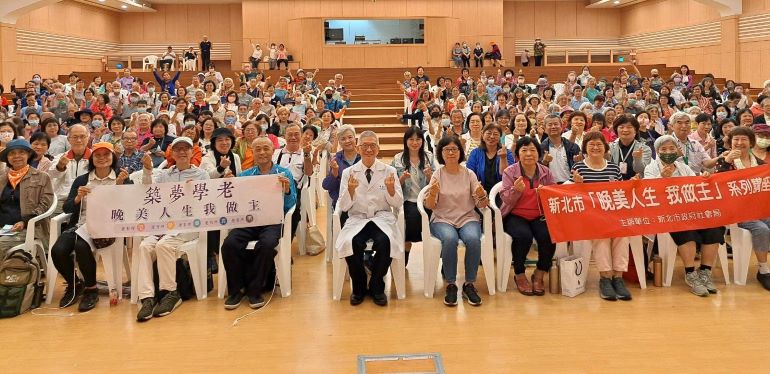 《圖說》李嘉富醫師在雙和靜思堂以「越老越快樂─不失眠、不憂鬱的腦心保養術」為題進行專題演講，吸引近300位民眾聆聽。中為李嘉富醫師，中右為社會局副局長許秀能。〈社會局提供〉