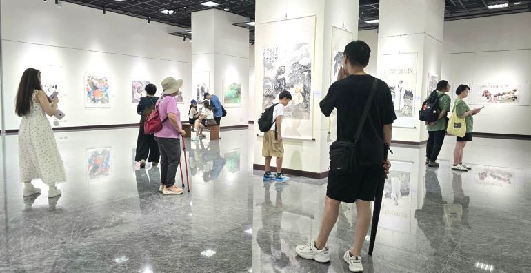 《圖說》何子書畫臺灣展的開展首日，觀者踴入展場，細心欣賞這難得一見的書畫作品，場面熱烈。〈主辦單位提供〉