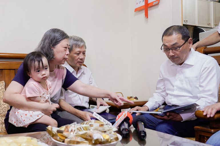 《圖說》寄養媽媽劉仙珍向侯友宜市長分享小立的照片，提起當年照顧點滴，昔日相處時光彷彿歷歷在目。〈社會局提供〉