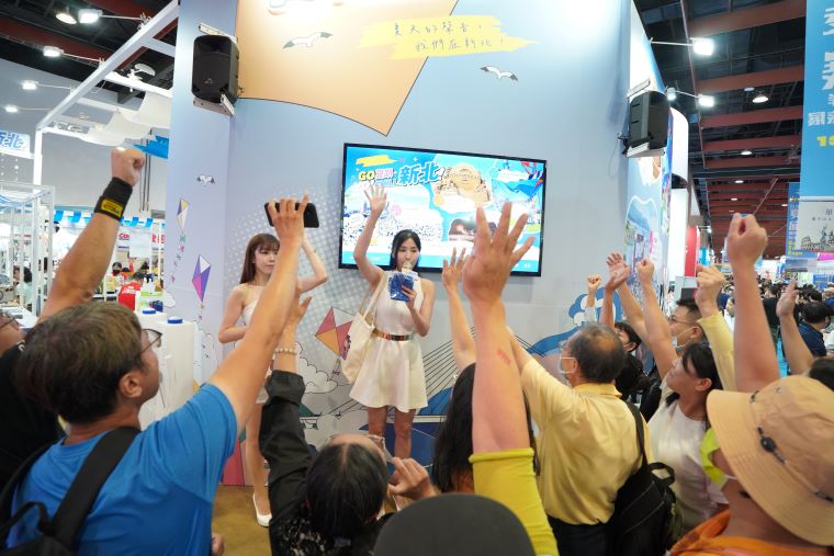 《圖說》夏季旅展新北館現場人潮互動踴躍，民眾熱情舉手搶答及搶拿活動小禮。〈觀旅局提供〉