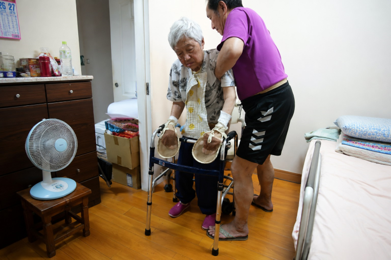 《圖說》吳澤欣耐心攙扶母親練習行走，以細心陪伴守護母親的生活自理能力。〈教育局提供〉