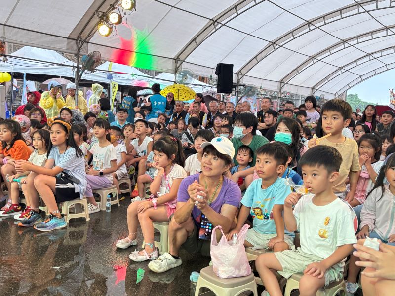 《圖說》大小朋友聚精會神及吃著「台電」贈送冰棒專心看劇。〈林口區公所提供〉