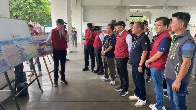 白海豚環流挾強風雨 侯友宜視察深澳漁港坐鎮應變中心 20 《圖說》農業局長諶錫輝向市長報告深澳漁港防颱整備工作。〈消防局提供〉