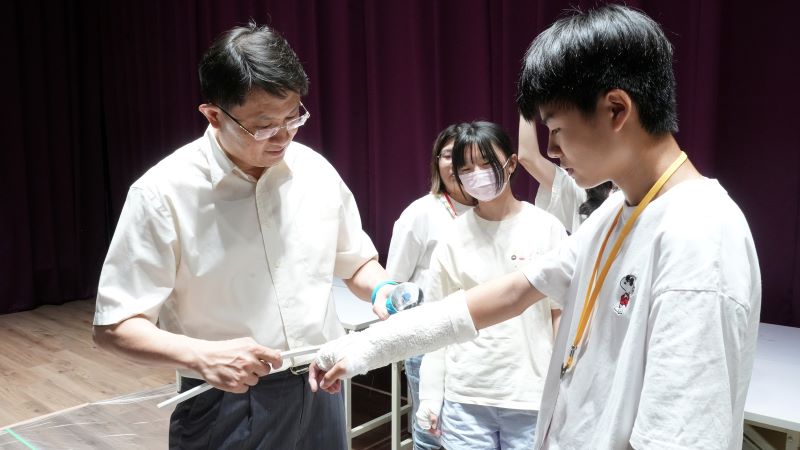《圖說》林同學(右一)在門診楊士賢主任醫師帶領下，體驗石膏包紮與切除。〈臺北醫院提供〉