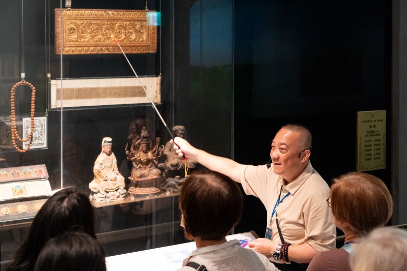 宗博館掌櫃講堂談藏傳淨土 葉靈毅帶讀《極樂願文》 24 《圖說》藏傳佛教研究者葉靈毅在世界宗教展示大廳導覽佛教展櫃。〈宗博館提供〉
