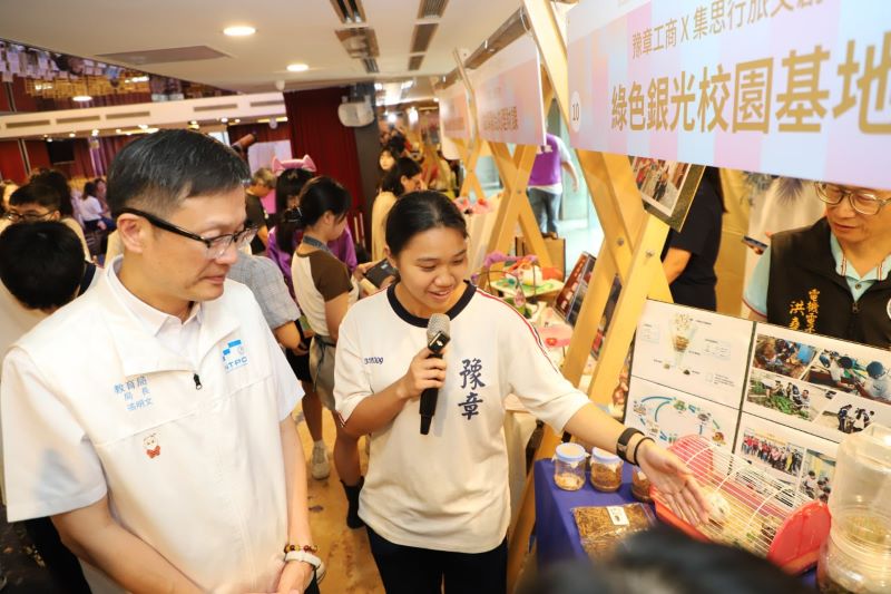 技職教育九連霸再創紀錄 新北全國唯一優等獲教育部百萬獎勵金 16 《圖說》豫章工商學生將課堂所學帶進社區,向教育局長張明文說明「綠色銀行校園基地」的循環經濟理念,展現技職教育結合永續實踐的學習成果。〈教育局提供〉