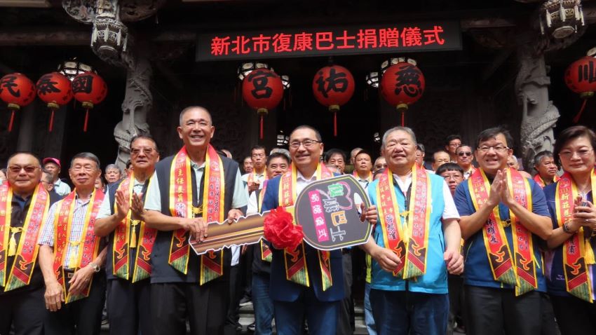 《圖說》新莊慈祐宮建廟340週年，為弘揚媽祖博愛濟眾精神，特別捐贈復康巴士回饋社會，由市長侯友宜代表受贈，右三議長蔣根煌、右二民政局長林耀長。〈民政局提供〉